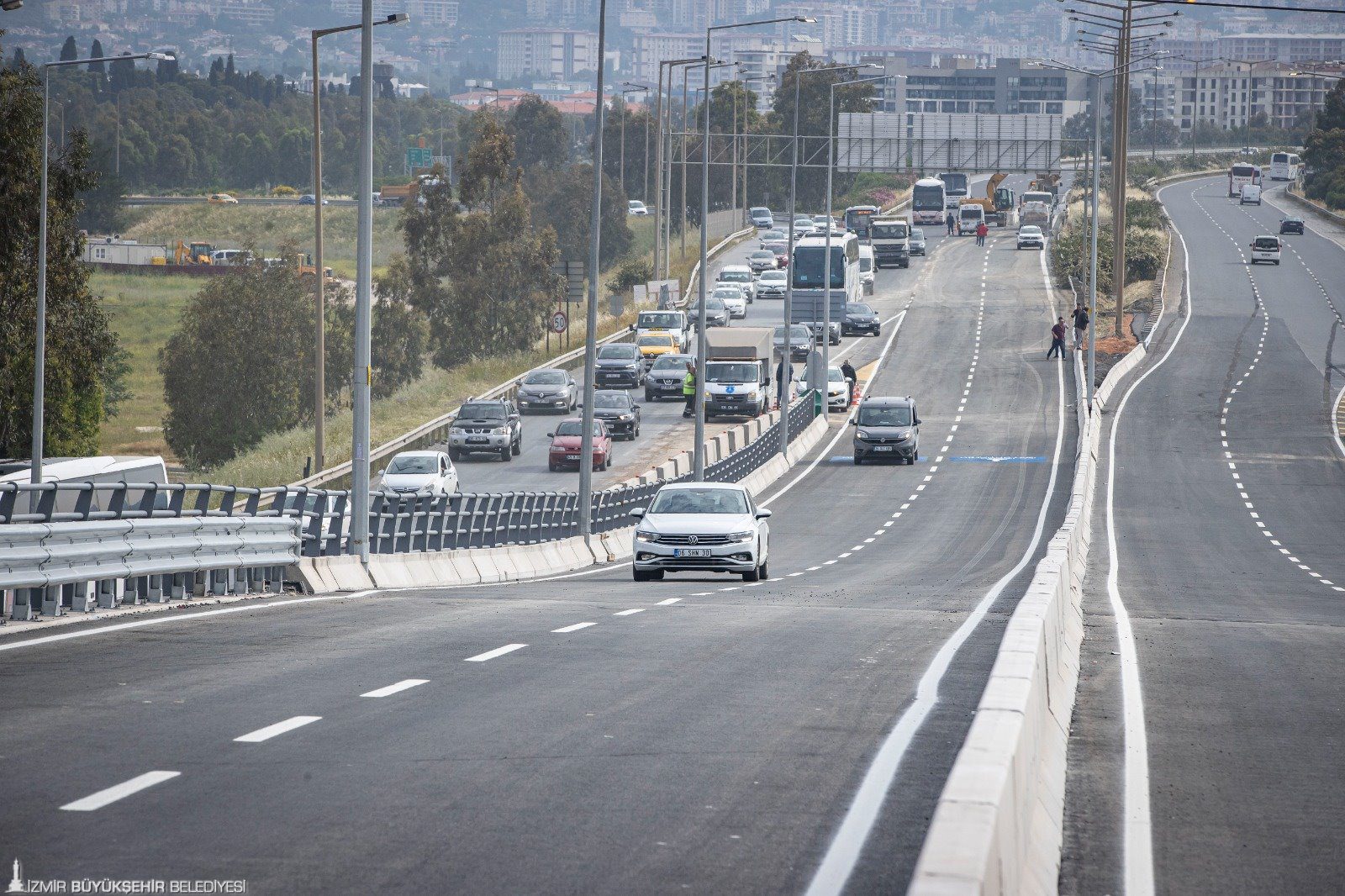yol <p>Buca ile Bornova’yı kesintisiz birbirine bağlayacak projenin 2,2 kilometrelik viyadük etabı hizmete açıldı. Bölgedeki trafiği rahatlatacak viyadükten aracıyla ilk geçen Başkan Tunç Soyer oldu. 2025’te tamamlanması planlanan projenin tünel etabında çalışmaların hızla ilerlediğini ifade eden Başkan Soyer, “Bugün İzmir için güzel bir gün, çünkü uzun zamandır çok ciddi bir yatırımla emek verdiğimiz projenin sonuna geldik. İzmir'e hayırlı olsun diyorum” dedi. İzmir Büyükşehir Belediyesi, Buca ile Bornova’yı birbirine kesintisiz bağlayacak “Buca Onat Caddesi ile Şehirlerarası Otobüs Terminali ve Çevre Yolu Arası Bağlantı Yolu” projesinin ikinci etabında devam eden Buca Onat Tüneli çalışmalarını hızla sürdürüyor.   Tünelin otogar üzerinden çevreyolu bağlantısını sağlayacak 2,2 kilometrelik viyadük etabı tamamlandı. İzmir Büyükşehir Belediye Başkanı Tunç Soyer ve İzmir Büyükşehir Belediyesi Genel Sekreter Yardımcısı Özgür Ozan Yılmaz'ın ilk sürüşüyle viyadükler hizmete açıldı. Viyadük ve alt geçitlerin hizmete girmesiyle Bornova ve terminal önündeki araç trafiği rahatlayacak.</p>
<p>Soyer: “Bugün İzmir için güzel bir gün”
İzmir Büyükşehir Belediye Başkanı Tunç Soyer, “Bugün İzmir için güzel bir gün, çünkü uzun zamandır çok ciddi bir yatırımla emek verdiğimiz projenin sonuna geldik. Viyadükleri açıyoruz. Buca Onat Tüneli tamamlandığında Buca Bornova arasındaki trafiği önemli ölçüde rahatlatacak. 170 milyon liralık bir yatırım gerçekleştirildi viyadüklerde. Bugünün rakamlarıyla yapılmaya kalkılsaydı, 500 milyon lirayı bulacak bir yatırım. Rakamsal büyüklüğü bir yana getirdiği çözüm bizim için çok daha önemli. O nedenle bütün arkadaşlarıma teşekkür ediyorum. İzmir'e hayırlı olsun diyorum. Tüneli de açtığımız zaman mükemmel bir çözümü İzmir için getirmiş olacağız” dedi.</p>
<p>45 dakikalık yol 10 dakikaya inecek
Konak Tüneli’nden başlayan ve otogar viyadüklerinde son bulan transit yolun en önemli etaplarından 7,1 kilometrelik Buca Onat Tüneli çalışmaları hızla sürüyor. 1 milyar 400 milyon liralık yatırımla devam eden tünel inşaatı tamamlandığında Konak ile Bornova arası 10 dakikaya inecek ve kent trafiği büyük ölçüde rahatlayacak. Tünel ve bağlantı yollarını kapsayan diğer çalışmaların da 2025’in ilk yarısında tamamlanıp İzmirlilerin hizmetine açılması planlanıyor.
Çalışmalar kapsamında iki tüpü birbirine bağlayan üç adet acil giriş noktası bulunuyor. Buca yönünde 650’inci metresindeki ilk geçiş tamamlandı. Projeyle havaalanından gelen bir yurttaş şehir trafiğine girmeden bu transit yolu kullanarak şehrin kuzey kesimlerine hızlı bir şekilde ulaşabilecek. Kuzey bölgesinden gelen yolcularsa otogar tarafından gelerek havaalanı, Çeşme gibi ilçelere ulaşım sağlayabilecek. Böylelikle 45 dakika olan seyahat süresi 10 dakikaya inecek.</p>
